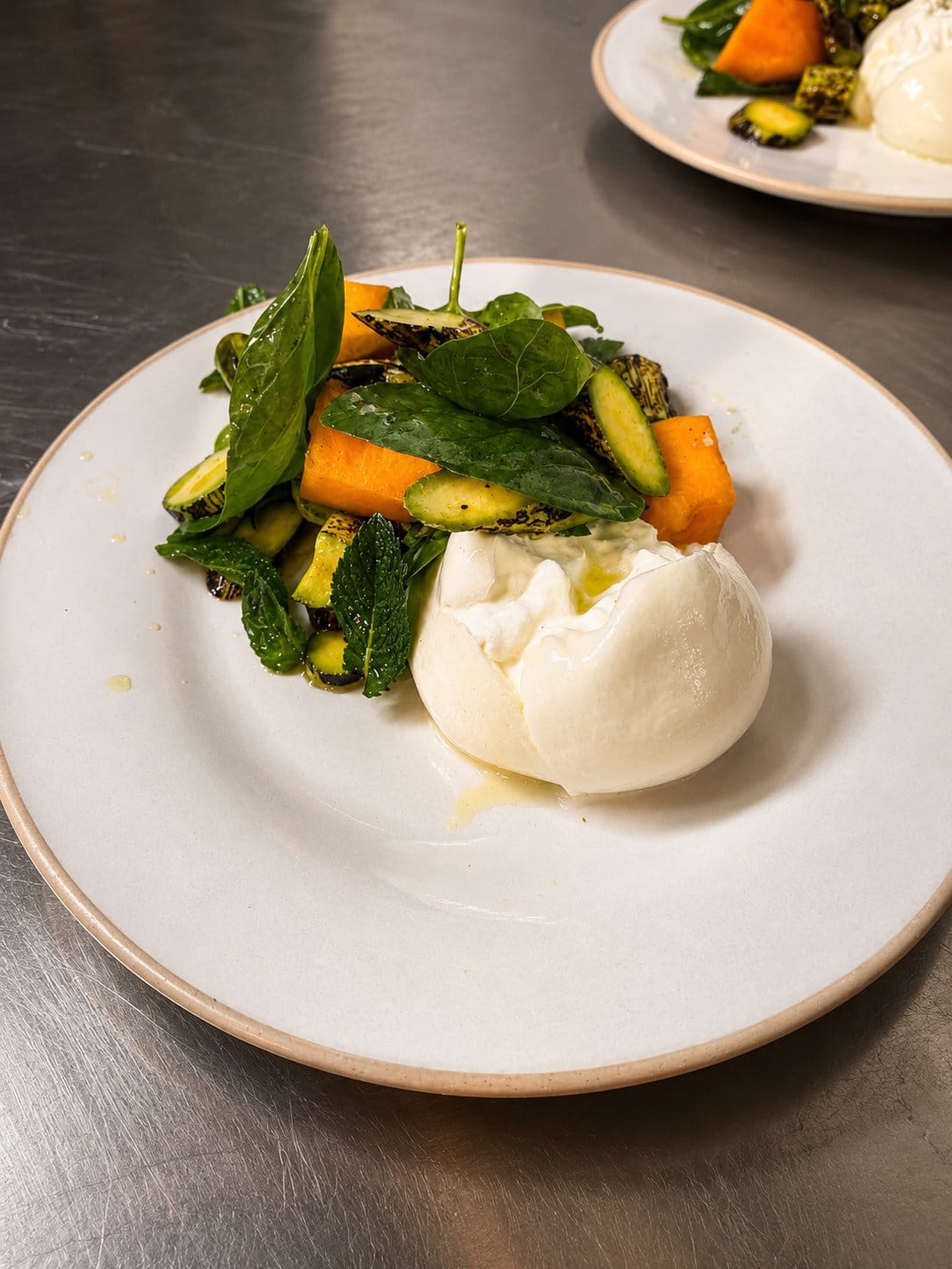 A burrata starter plated in the Latimers kitchen