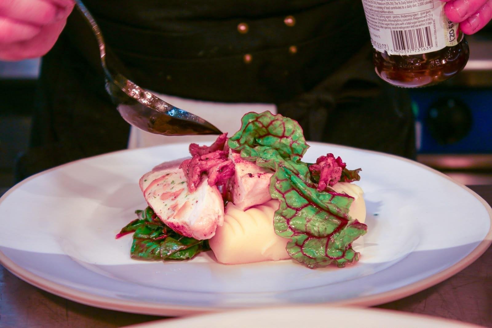 A dish being finished with sauce in the Latimers kitchen